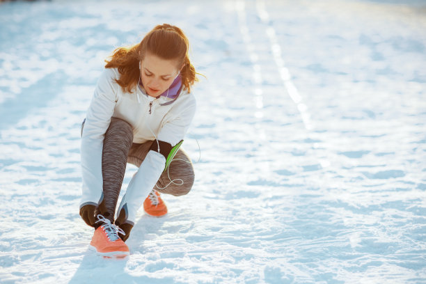 穿着白夹克的活跃女人帮你系鞋带图片下载