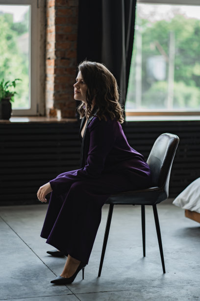 一个穿着紫色裤装的褐发年轻女子出现在橱窗的背景上图片下载
