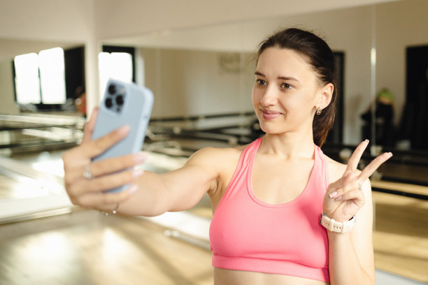 运动有问题。年轻有魅力的女子在家中室内的垫子地板上开始锻炼之前，为自己拍照显示和平迹象图片下载