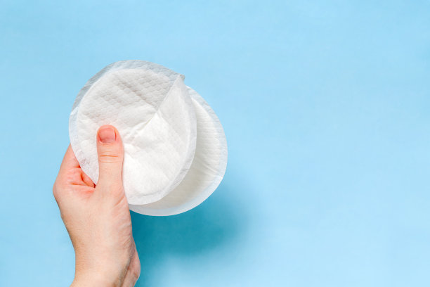 白色的胸罩垫在蓝色的背景。母乳喂养，保护理念。图片下载