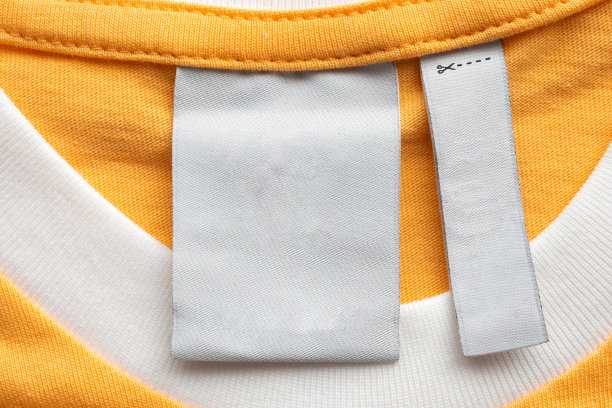 空白白色洗衣护理衣服标签上的黄色织物纹理背景图片下载