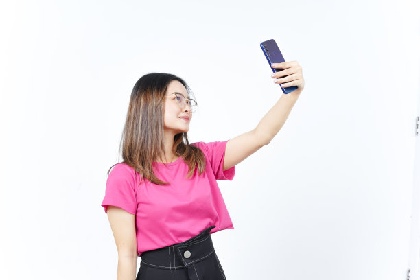 用智能手机自拍一张白色背景下的美丽亚洲女子图片下载