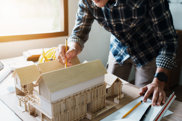 工程师们使用蓝图、尺子、铅笔、隔板和建筑模型来设计房屋结构和建筑结构图片下载