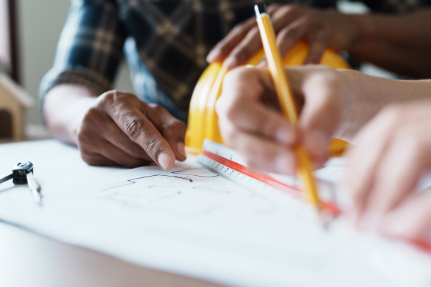 工程师们正在咨询团队，为客户设计一个建筑结构，有蓝图和建筑模型，可以在办公室工作图片下载