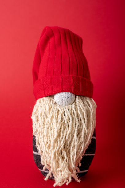 红色背景上手工制作的圣诞侏儒图片下载