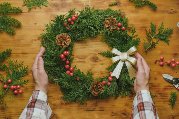 手捧圣诞花环。DIY冬季花卉装饰。图片下载