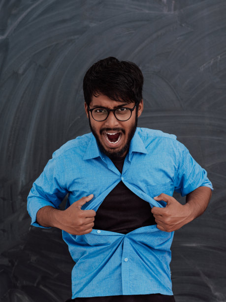 一个印度男孩在学校黑板前展示超人标志的象征性照片图片下载