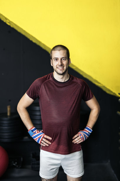 一个微笑的年轻肌肉自由搏击运动员看着相机的肖像图片下载