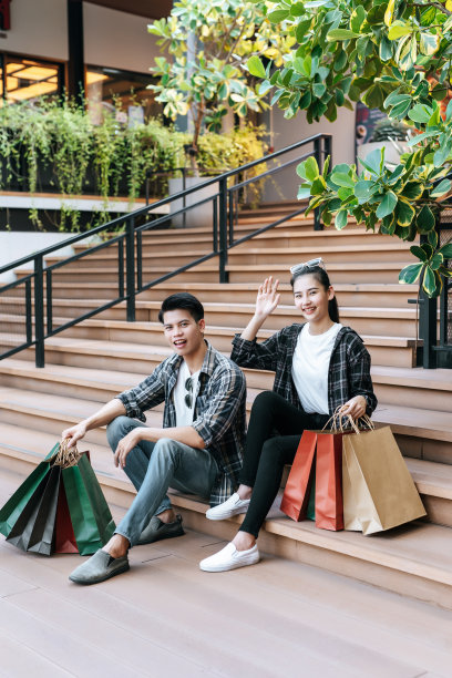 幸福的情侣拿着多个购物纸袋在商场图片下载