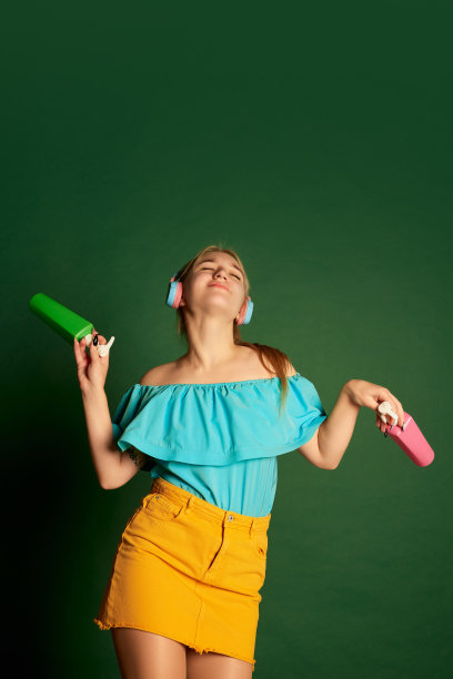 音乐、舞蹈。年轻美丽的女孩的肖像，学生在夏装摆孤立的绿色背景。积极的情绪，快乐，爱好和快乐图片下载