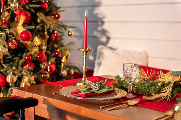 漂亮的桌子设置与圣诞装饰和餐具在客厅。家里圣诞晚餐的节日餐桌摆设。餐桌上摆满了装饰品、蜡烛和花环。图片下载
