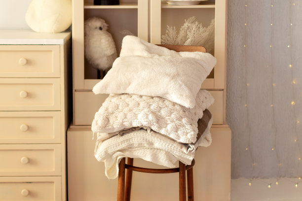 配有家用纺织品和毛毯的木椅。舒适的家居概念。居家斯堪的纳维亚风格。你好,秋天。舒适的室内与旧的复古椅子，温暖的格纹，堆软靠垫靠近墙壁。圣诞假期图片下载