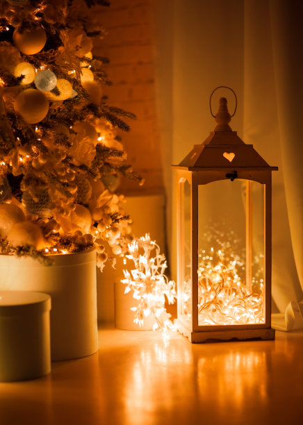 地板上摆放着复古风格的灯笼、烛台。里面是一个圣诞花环。摄影在温暖的金色色调，夜晚图片下载