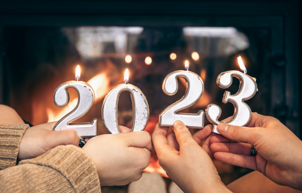 女性手中的蜡烛形状为数字2023。图片下载