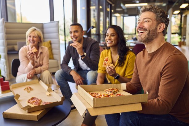 员工在办公室举行非正式会议，提供外卖披萨和饮料图片下载