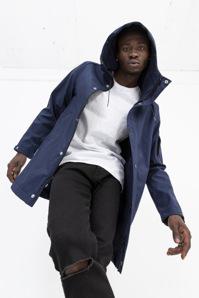 一名黑人男模特穿着牛仔夹克，前面是白色背景。图片下载
