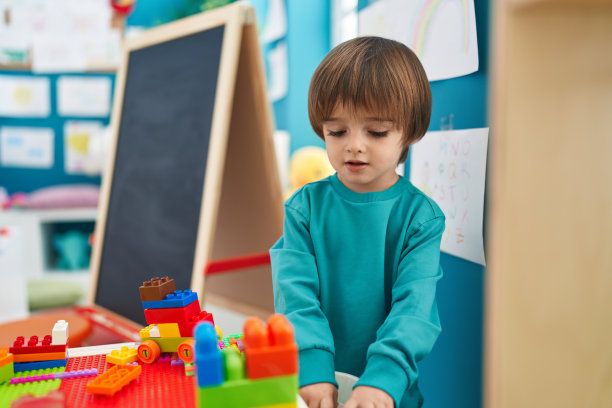 可爱的幼儿站在幼儿园玩积木图片下载