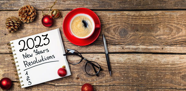 2023年的新年决心在桌子上。2023决心清单，笔记本，咖啡杯，桌子上的装饰品。目标，决心，计划，行动概念。2023年新年背景图片下载