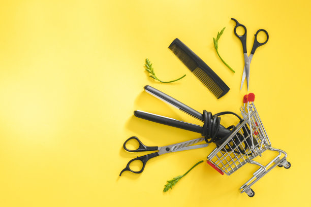 剪刀、梳子、头发剪、耳朵剪、鼻子剪在一个黄色的迷你推车上。图片下载