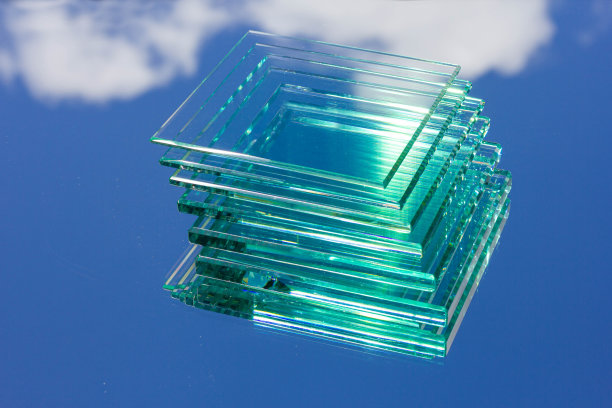 来自工厂的各种尺寸的透明玻璃排列在几片上，放在反射天空的玻璃上图片下载