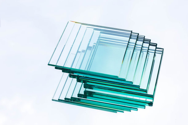 来自工厂的各种尺寸的透明玻璃排列在几片上，放在反射天空的玻璃上图片下载