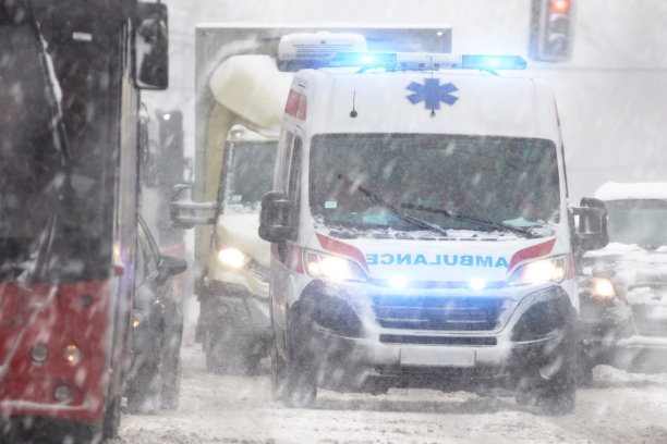 911救护车在冬季大雪天气中冲过车流。图片下载
