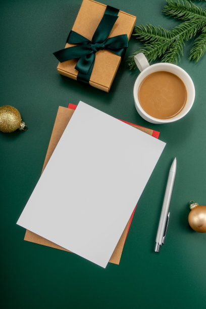 家庭办公室桌子，圣诞装饰品，咖啡杯，键盘，纸质笔记本。圣诞节的工作区。图片下载