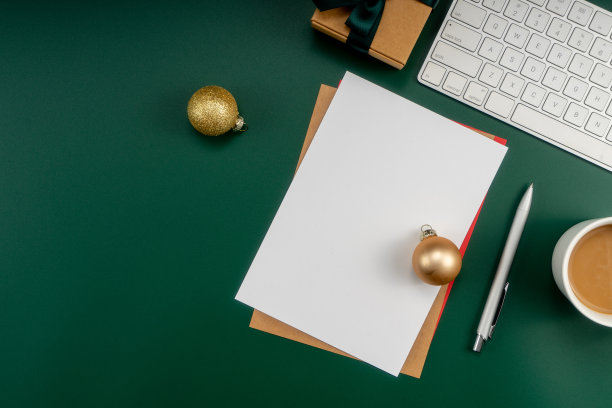 家庭办公室桌子，圣诞装饰品，咖啡杯，键盘，纸质笔记本。圣诞节的工作区。图片下载