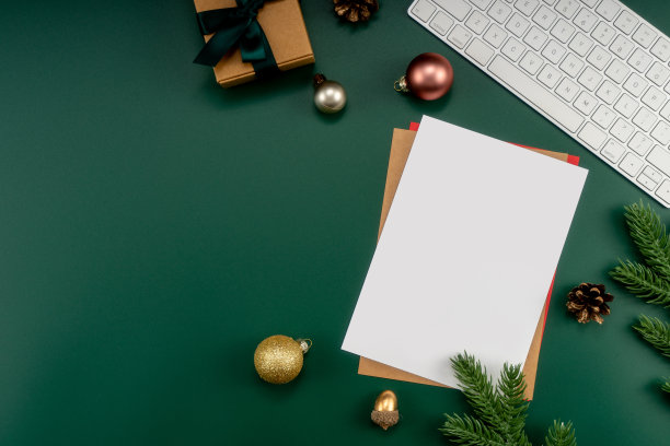 家庭办公室桌子与圣诞装饰，键盘，纸质笔记本。圣诞节的工作区。图片下载