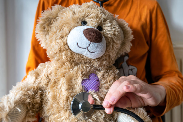 孩子以儿科医生为主题，用听诊器顽皮地检查可爱的玩具图片下载