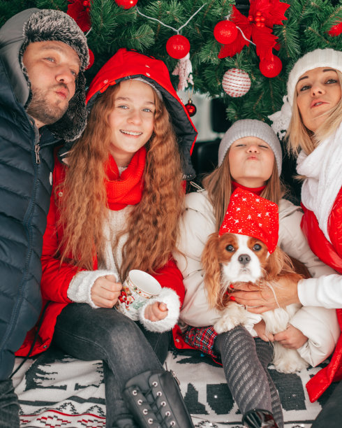 家庭幸福爸爸妈妈2个女孩给你飞吻。圣诞派对在汽车卡车。红色的圣诞装饰。快乐的心情。幸福。图片下载