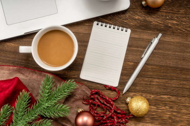 笔记本电脑和记事本与饰品球在木桌上。图片下载