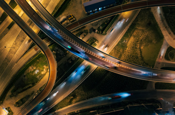 高速公路路口的鸟瞰图。城市多条高速公路夜间高峰时段的交通状况。工业城市交通运输和货物配送。图片下载
