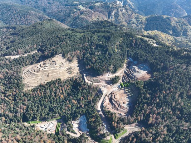 工业矿山挖掘机正在施工现场挖土，装载卡车。无人机俯视图。图片下载