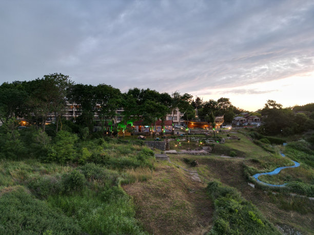 日落时分，绿色山顶上的房屋被街灯照亮图片下载