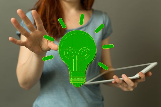女商人拿着平板电脑，伸手去摸3D渲染的绿色灯泡——理念、能量的概念图片下载