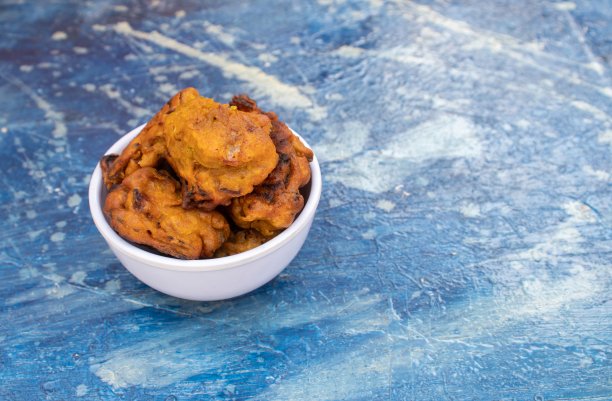 Masoor Dal Pakoda或红扁豆Vada的特写，在白色碗中隔离在蓝色背景上，复制空间图片下载