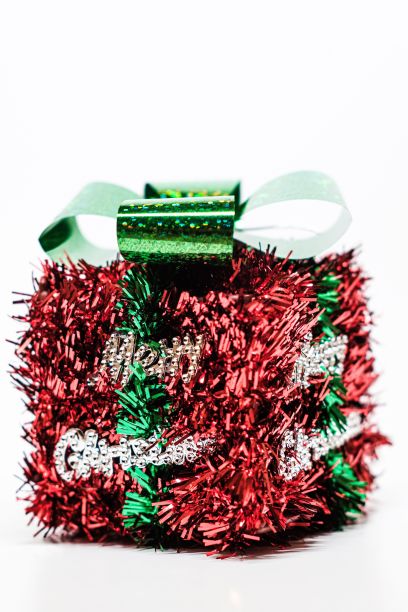 白色背景上红色花环和绿色丝带的圣诞礼盒的垂直特写图片下载