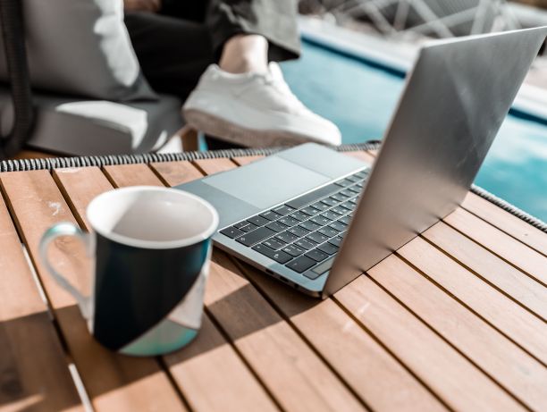 有选择性地拍摄了一台笔记本电脑放在户外桌子上，上面放着一个马克杯图片下载