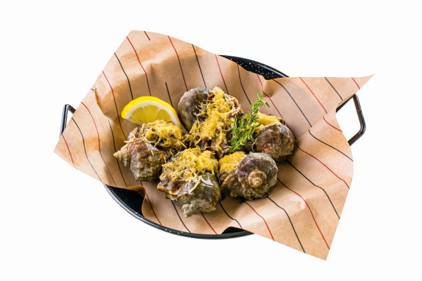 在烤箱里用奶酪和百里香烤过的Rapana。附近有一个柠檬角。食物放在有黑色和红色条纹的棕色羊皮纸上，放在一个带把手的黑色金属模具里。白色背景。图片下载