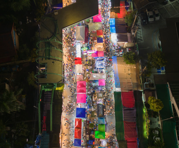 夜市庙会和当地夜市的游乐园鸟瞰图。人们走在街上，五颜六色的帐篷在曼谷市，泰国。零售商店图片下载