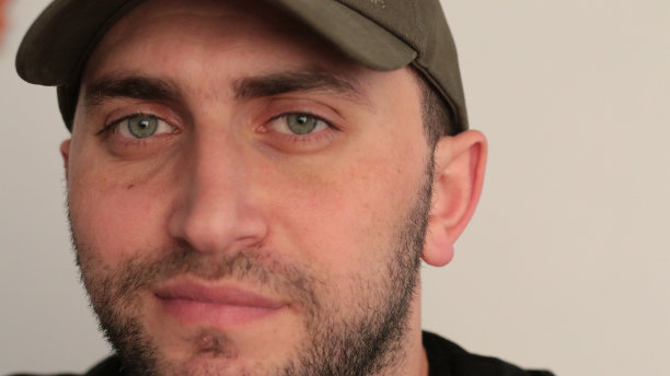 戴着帽子，眼睛红润的年轻男子微笑着图片下载