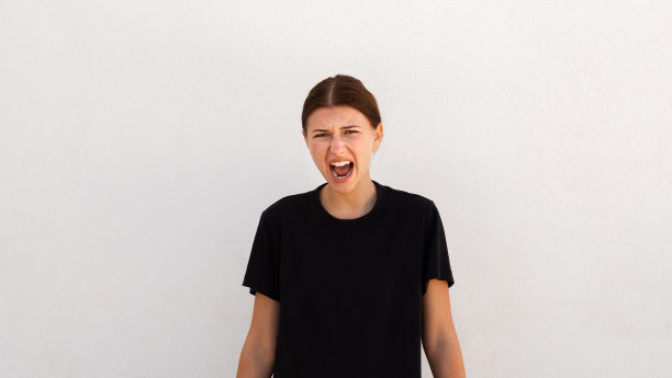 愤怒的年轻女子在白色背景上大喊大叫的肖像图片下载
