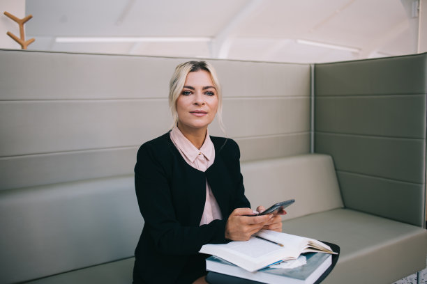 在现代工作空间使用商业文献和智能手机小工具进行信息研究的专业员工的肖像，白人企业家与手机技术摆拍图片下载