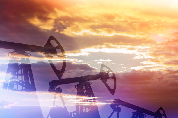 日落背景下的石油生产。钻井平台。油田。图片下载