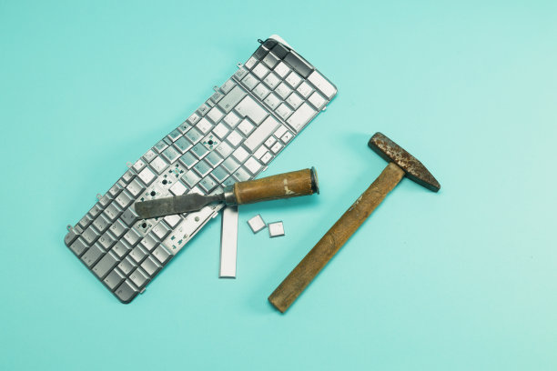 用锤子和凿子敲电脑键盘，键盘损坏。图片下载