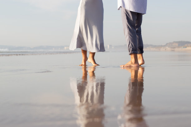 男性和女性光脚在水中的特写图片下载