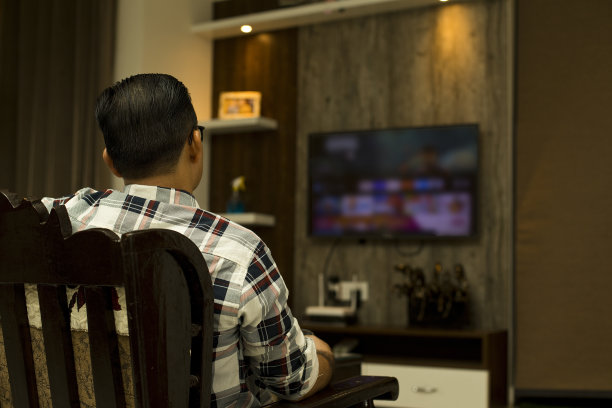 男人在家里的客厅里看电视图片下载