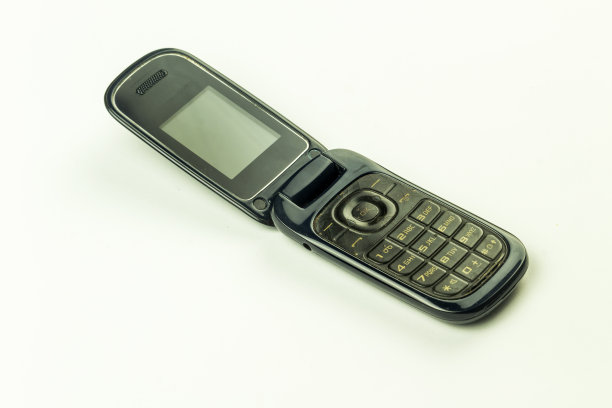 老式翻盖手机孤零零地放在白色背景上图片下载