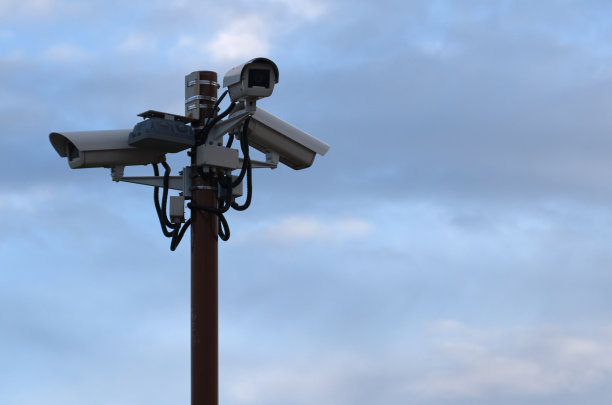 户外监控摄像头挂在背对天空的杆子上图片下载